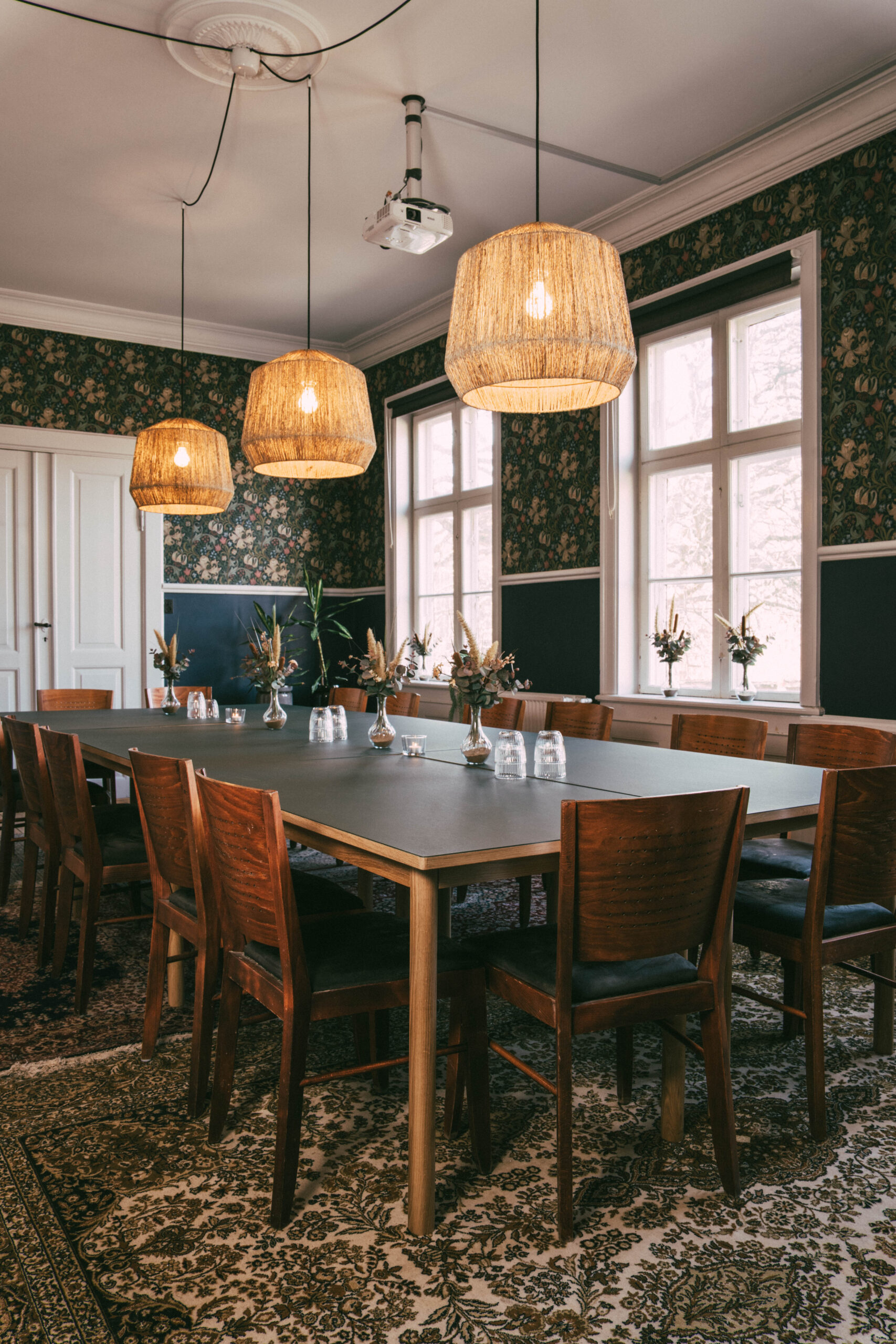 Mødestuen på Camp Adventure med langbord, blomster og varme lamper